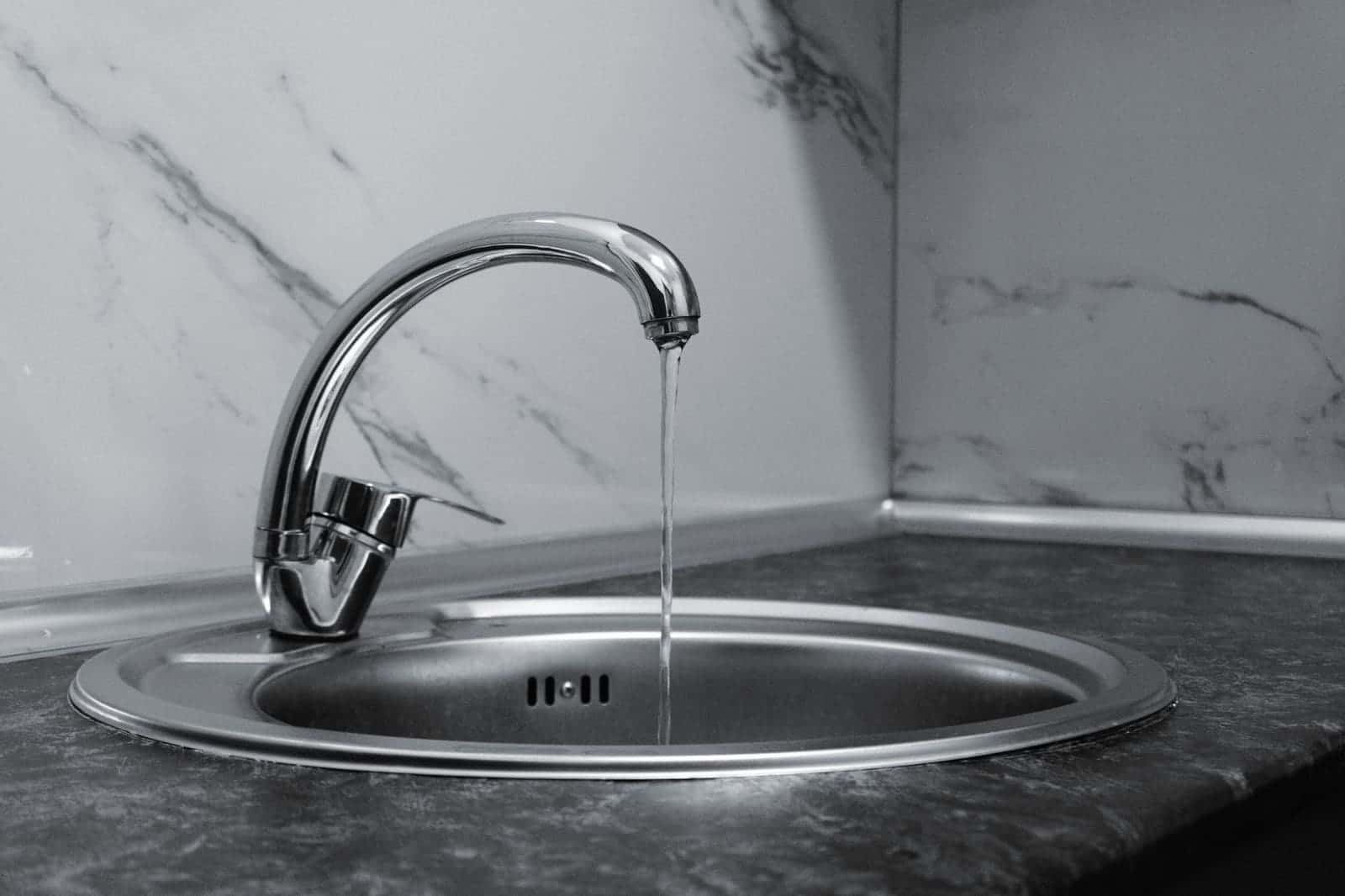 Chrome kitchen faucet running into a sink